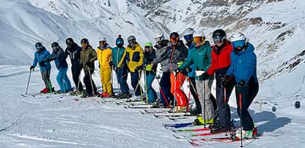 Ski instructor preparation course with trainees practicing formations on a snowy slope